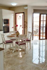 a dining room with a table and chairs and a kitchen at Yellow! in Costa Del Silencio