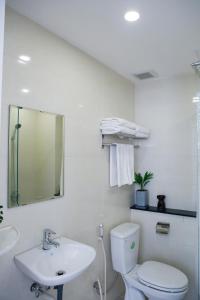 een witte badkamer met een toilet en een wastafel bij Angie's Home in Ho Chi Minh-stad