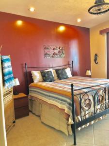 um quarto com uma cama com uma parede vermelha em BELLA SIRENA RESORT em Puerto Peñasco