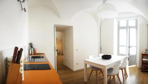 a kitchen with a white table and a white dining room at Ca del Lac in Castro