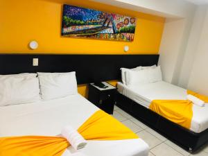 a hotel room with two beds and a painting on the wall at Hotel Belisario INN in Guadalajara