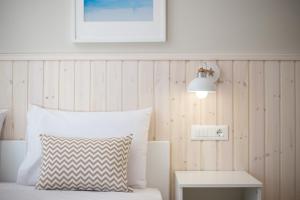 a bedroom with a bed with a pillow and a lamp at Avi Suites 2 in Faliraki