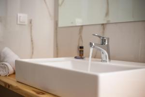 a white sink with a faucet in a bathroom at Avi Suites 2 in Faliraki