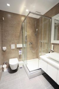een badkamer met een douche, een toilet en een wastafel bij Carpe Diem Boutique Hotel in Zenica