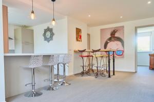 een keuken met barkrukken in een kamer bij Le Rayon de Soleil - appartement 2 chambres 90m2 in Saint-Brieuc