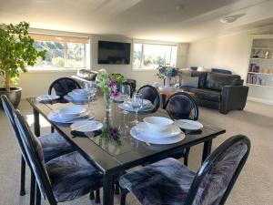 Mariri Heights Tasman في Upper Moutere: غرفة طعام مع طاولة وكراسي