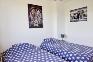een slaapkamer met twee bedden en twee foto's aan de muur bij Le Rayon de Soleil - appartement 2 chambres 90m2 in Saint-Brieuc