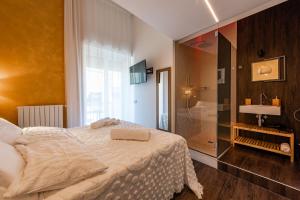 a bedroom with a bed and a glass shower at Sinestesia in Polignano a Mare