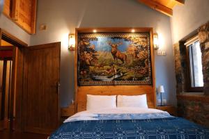 1 dormitorio con 1 cama con tapiz en la pared en Casa Kedrova, Mountain Voras-Kaimaktsalan Edessa, en Kedhróna