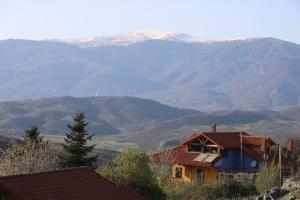 una casa en una colina con montañas en el fondo en Casa Kedrova, Mountain Voras-Kaimaktsalan Edessa, en Kedhróna