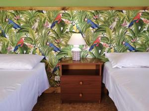 a bedroom with two beds and a table with a lamp at Ostello delle cartiere in Toscolano Maderno