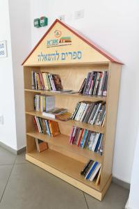 a book shelf filled with books on top of each other at HI - Eilat Hostel in Eilat