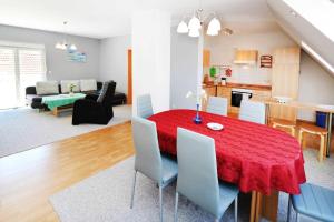 - une salle à manger et un salon avec une table et des chaises rouges dans l'établissement Fewo Urlaubsidyll 2_GUeTH, à Karlshagen