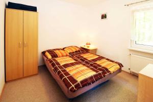 a bedroom with a bed and a cabinet and a window at Fewo Urlaubsidyll 2 in Ostseebad Karlshagen