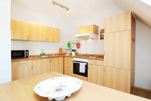 a small kitchen with wooden cabinets and a table at Fewo Urlaubsidyll 2_GUeTH in Ostseebad Karlshagen