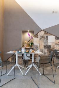 a dining room with a white table and chairs at Sinestesia in Polignano a Mare