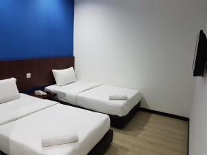 a room with two beds and a tv at Sun Inns Hotel @ Koi in Puchong