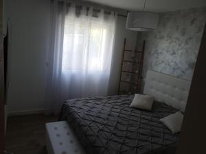 - une chambre avec un lit et une fenêtre dans l'établissement Appartement Confortable, à Biguglia