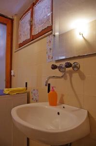 a bathroom sink with a bottle of orange soap on it at Large and charming apartment near beach with big & sunny terrace in Sumartin