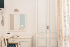Jest to biały pokój z białą szafką i lustrem. w obiekcie Hotel Altair w mieście Misano Adriatico