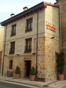 a building with a sign on the side of it at Hostal Restaurante La Muralla in Oña