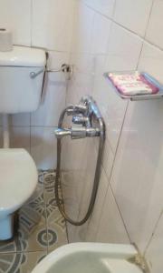 a bathroom with a hose hooked up to a toilet at Tembo Safari Lodge in Katunguru
