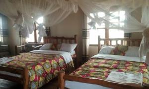 En eller flere senger på et rom på Tembo Safari Lodge