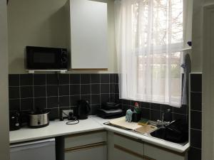 a kitchen with a sink and a microwave at Bourton House in Rugby