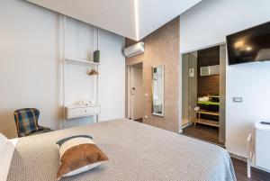 a bedroom with a large bed and a tv at Sinestesia in Polignano a Mare