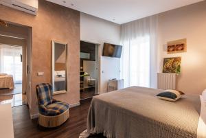 a bedroom with a bed and a chair at Sinestesia in Polignano a Mare