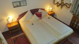 a bedroom with a bed with white sheets and pillows at s'Landhaus in Sankt Anton am Arlberg