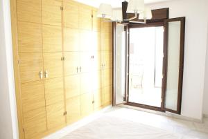 Pokój z drewnianymi szafkami i oknem w obiekcie Modern Atico, Close Macarena/Sevilla center w Sewilli