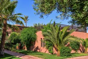 un bâtiment avec des palmiers en face de celui-ci dans l'établissement Maison Ayda, à Marrakech