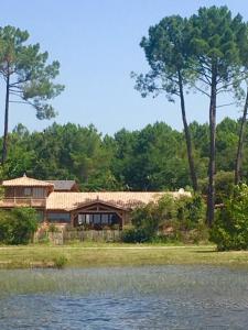 a house sitting on the side of a lake at La Maison Moutchic in Lacanau