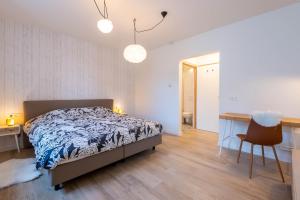 a bedroom with a bed and a desk and a chair at De Lokroep in Heers