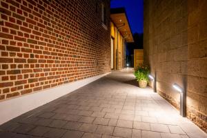 an alley with a brick wall and a potted plant at De Lokroep in Heers +46 photos