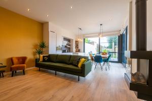 a living room with a green couch and a table at De Lokroep in Heers
