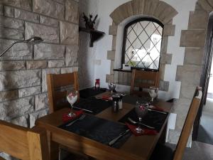 a wooden table with glasses on top of a stone wall at EX-MINERS COTTAGE, BLAENAVON, NEAR ABERGAVENNY in Blaenavon