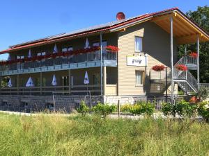 巴登-巴登Die Wein Bleibe的一座在阳台上种满鲜花的建筑,上面有标志