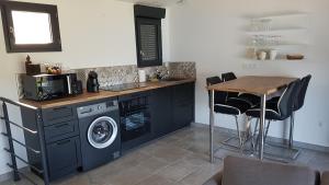 a kitchen with a washing machine and a wooden table at La Frache in Sainte-Croix-de-Verdon