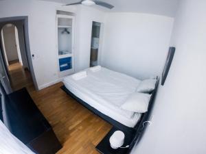 ein kleines Schlafzimmer mit einem Bett und einem Holzboden in der Unterkunft D’AGOSTA Beach Apartment in Alcúdia