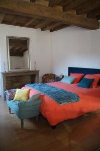 una camera con letto, sedia e specchio di Dolce Vita a Chalon-sur-Saône
