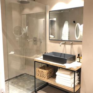La salle de bains est pourvue d'un lavabo et d'une douche en verre. dans l'établissement LA SUITE VALBONNE, à Valbonne