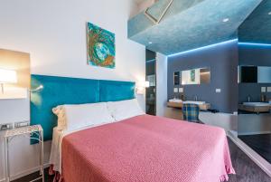 a bedroom with a large bed with a pink blanket at Sinestesia in Polignano a Mare