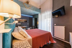 a bedroom with a bed with a red blanket and a tv at Sinestesia in Polignano a Mare