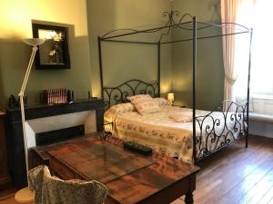 サン・ジュニアンにあるLe Clos de La Museのベッドルーム1室(ベッド1台、ガラステーブル付きのテーブル付)