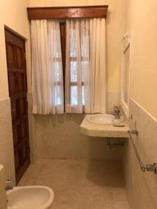 Un baño con lavabo, inodoro y ventana. en Tembo Court Apartment 164, en Malindi