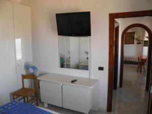 a bedroom with a white dresser and a mirror at Villa Gesualda in Ischia