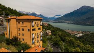 un edificio sul fianco di una montagna con un lago di Albergo De Jean a Garzeno