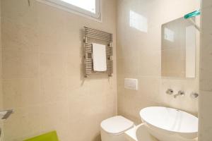 La salle de bains est pourvue de toilettes blanches et d'un lavabo. dans l'établissement Cà degli Archi, à Venise